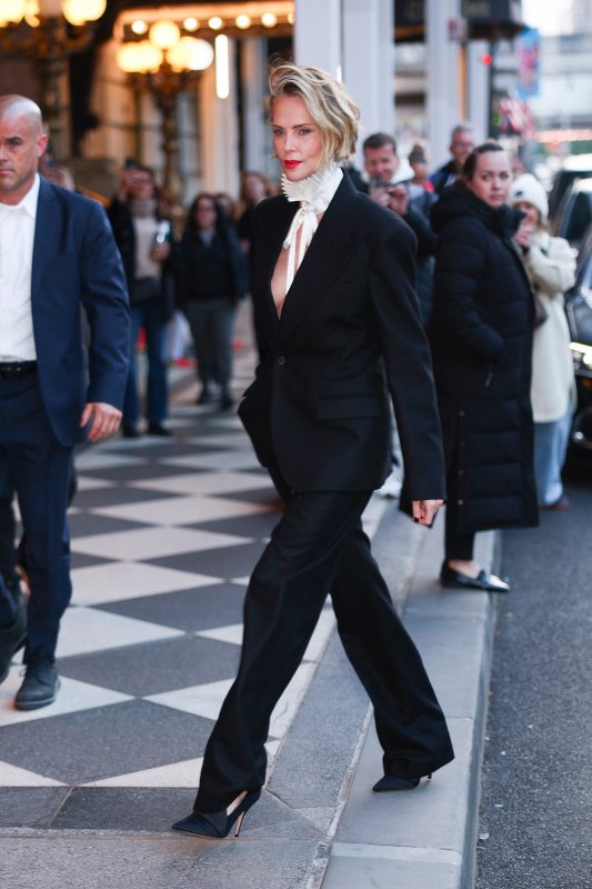 Charlize Theron sin camisa bajo la americana pero con lechuguilla barroca: un look sencillo pero de impacto rotundo para promocionar ‘Apex’